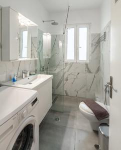 a white bathroom with a washing machine in it at Psiri gem from In Vivo Apartments- Spacious 1st floor Apartment with Balcony in Athens' historic center in Athens