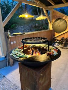 a large fire pit in a building with food in it at BO LODGE in Le Bourg-dʼOisans