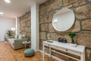 uma casa de banho com um espelho numa parede de pedra em GuestReady - Grandeur River Terrace no Porto