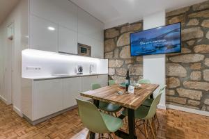 uma cozinha e sala de jantar com uma mesa de madeira e cadeiras em GuestReady - Grandeur River Terrace no Porto