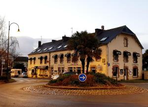 a building with a palm tree in front of a street at Hotel Robic - Salles de séminaires & Bar in Pontivy