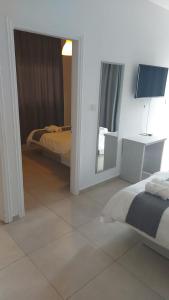 a bedroom with a bed and a mirror in it at La Veranda Hotel in Larnaca