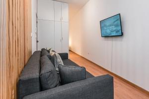 a living room with a couch and a tv on a wall at GuestReady - Yazdah Flat 3 in Porto