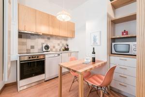 Il comprend une petite cuisine avec une table et des chaises en bois. dans l'établissement GuestReady - Yazdah Flat 3, à Porto