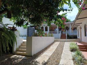 a house with a white fence and some stairs at Villa Clara Casa Campestre, Piscina, Naturaleza, Paseo de Río in Melgar