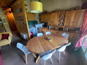 Bel appartement au décor Montagnard - 80m2 في لي كونتامين مونتجوا: مطبخ مع طاولة وكراسي خشبية