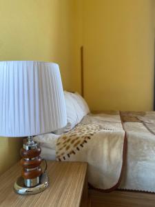 una lámpara sentada en una mesa junto a una cama en GS Hotel, en Tiflis