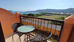 una mesa y sillas en un balcón con vistas en Jurerê Beach Village, en Florianópolis