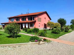 a pink house with a yard and a driveway at Agriturismo Podere Amati in Budrio