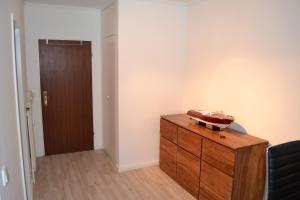 Zimmer mit Holzkommode und Tür in der Unterkunft 1-Zimmer-Appartment Miami in Timmendorfer Strand