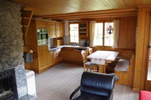 a kitchen with a table and chairs and a fireplace at Ferienwohnung Betula in Schwarzsee