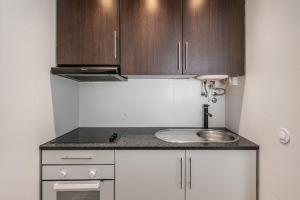 a small kitchen with a sink and wooden cabinets at GuestReady - Breathtaking view at Matosinhos in Matosinhos
