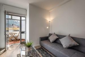 salon z kanapą i szklanym stołem w obiekcie GuestReady - Breathtaking view at Matosinhos w mieście Matosinhos