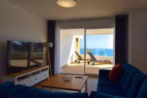 salon z niebieską kanapą i widokiem na ocean w obiekcie MAGNOLIO APARTMENT CALACEITE w mieście Torrox Costa