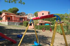 a swing set in a yard in front of a house at Residence Villa Franca in Capoliveri