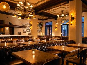 a restaurant with wooden tables and leather chairs at The Hollywood Roosevelt in Los Angeles