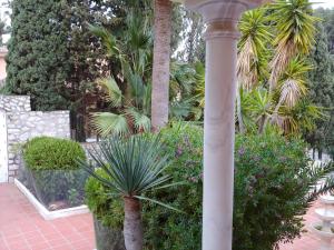 una columna en un jardín con árboles y plantas en Beautiful modern 4 bedroom villa with heated pool and cinema in Las Lagunas de Mijas, en Santa Fe de los Boliches