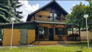 a yellow and green house with a balcony at Kuca Ribarev san in Beočin