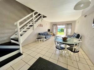 a living room with a staircase and a table at 42 Settler Sands Beachfront Accommodation Sea and River View in Port Alfred