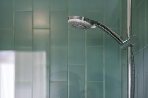 een douche met een douchekop naast een glazen deur bij GuestReady - Porto Home 6 in Porto