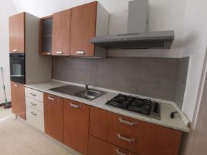a small kitchen with a stove and a sink at La Fontana in Gallipoli