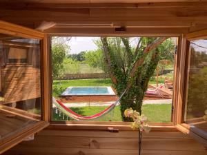 a window of a house with a hammock in a yard at Roulottes & SPA du pont des charrettes in Uzès