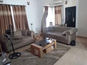 2 bedroom service apartment with full services في Idimu: غرفة معيشة مع كنبتين وطاولة قهوة