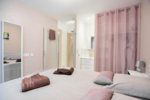 1 dormitorio con 1 cama grande y 2 toallas. en Les Perles de Vals - Améthyste, en Vals-les-Bains