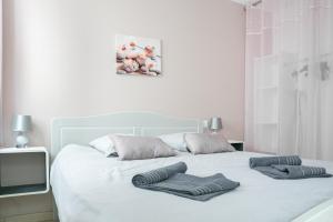 um quarto com uma cama branca com duas toalhas em Les Perles de Vals - Améthyste em Vals-les-Bains