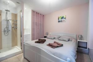 um quarto com uma cama branca com duas almofadas em Les Perles de Vals - Améthyste em Vals-les-Bains