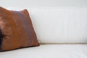 a brown pillow sitting on a white couch at GuestReady - Porto Home 6 in Porto