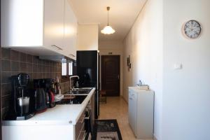 een keuken met witte kasten en een witte koelkast bij Agapi 's Place in Pylos