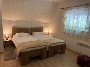 a bedroom with two beds and a window at Holiday Home Vanda in Zlobin