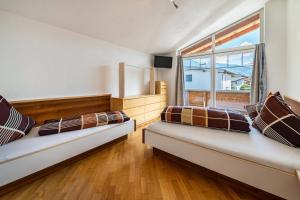 2 camas en una habitación con ventana en Haus Rudi, en Ried im Zillertal