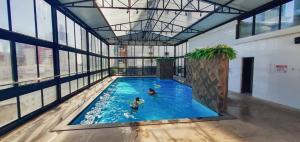 two people in a swimming pool in a building at Hotel das Américas in Balneário Camboriú