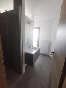 a white bathroom with a sink and a window at Gästehaus Apollo in Schwangau