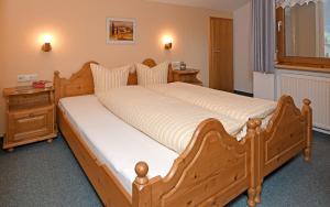 Una cama grande de madera en un dormitorio con escritorio en Rüf Wohlfühl-Apartments, en Au im Bregenzerwald 28 fotos más