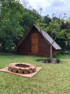 un piccolo edificio con una porta di legno nell'erba di Casa Santa Teresita - Cabaña familiar tipo glamping a Sanarate