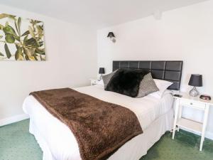 a bedroom with a large bed with a brown blanket at Triangle Inn Coachouse in Rhayader