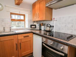 a kitchen with a sink and a stove top oven at Triangle Inn Coachouse in Rhayader