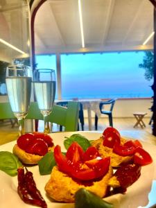 un plato de comida con tomates en una mesa con copas de vino en Casa La Quercia, en Marina Porto