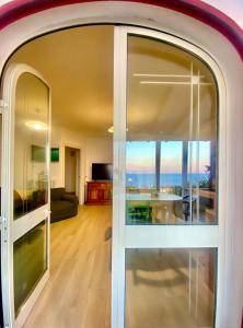 Casa La Quercia في مارينا بورتو: غرفة مع باب زجاجي منزلق مع غرفة معيشة