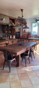 una cocina con una gran mesa de madera y sillas en Évasion Luxueuse en Drôme Provençale, en Rochegude