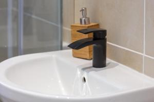 a black faucet on a white sink in a bathroom at ENTIRE Lovely Scottish Cottage in Selkirk