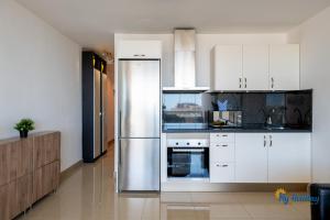 a kitchen with white cabinets and a stainless steel refrigerator at Esther's Sea View in Playa del Ingles