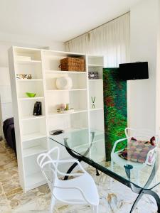 een woonkamer met een glazen tafel en stoelen bij Guest House in Taranto