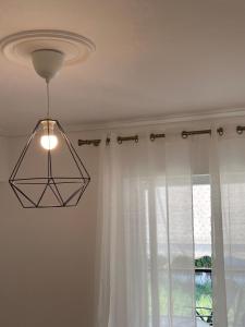 una luz colgando del techo con una ventana en DM home (sea view apartment) en Lefkandi Chalkidas