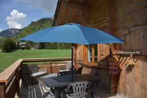 a blue umbrella sitting on a table on a deck at Chalet L'Armoy in La Giettaz