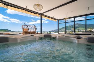 a hot tub in a room with large windows at Hotel Millennium by Aycon in Budva