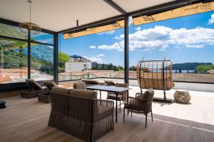 a room with a table and chairs and a large window at Hotel Millennium by Aycon in Budva
